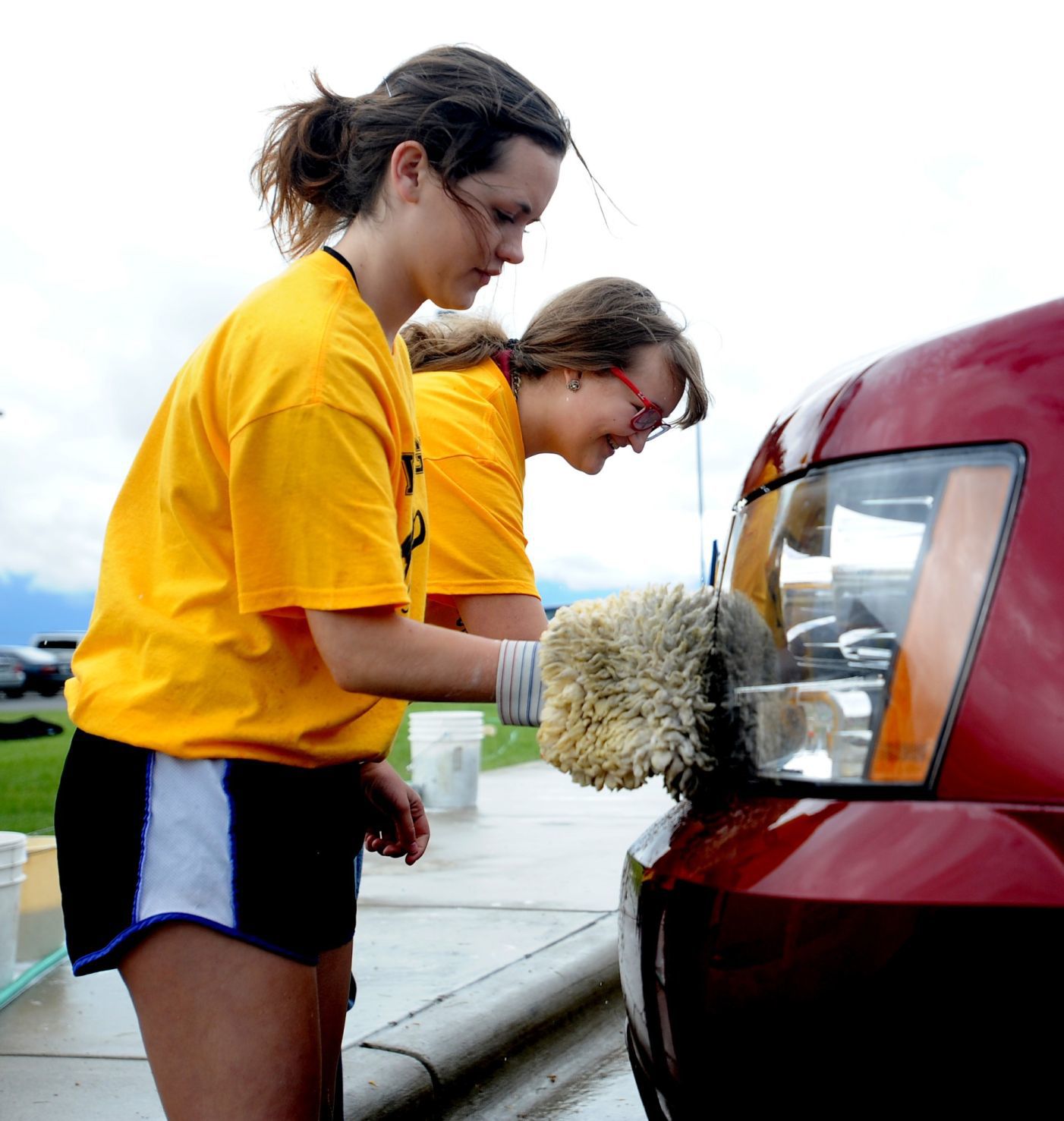 Casey Nelson and Madison Nelson wash a car